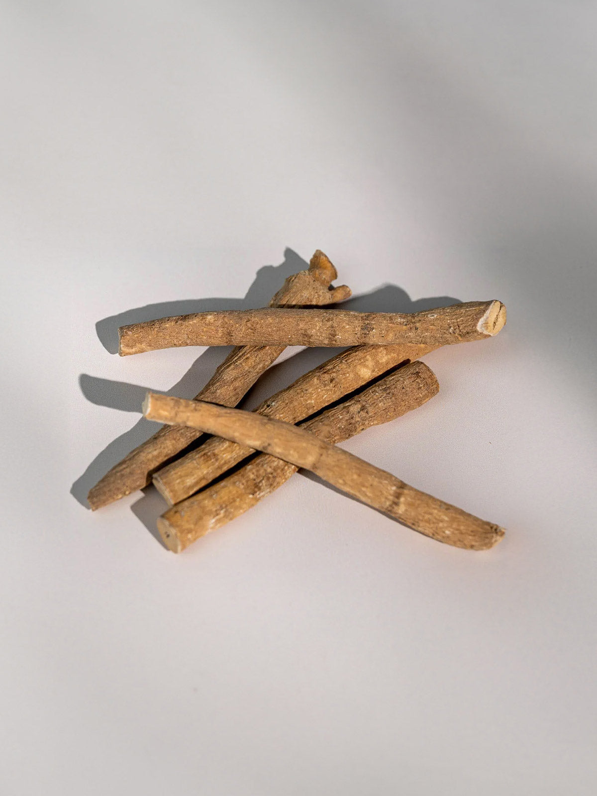 Getrocknete Ashwagandha-Wurzeln (Withania somnifera) auf hellem Hintergrund – Rohstoff für Bio Ashwagandha KSM-66 Tabletten von Kurkraft.